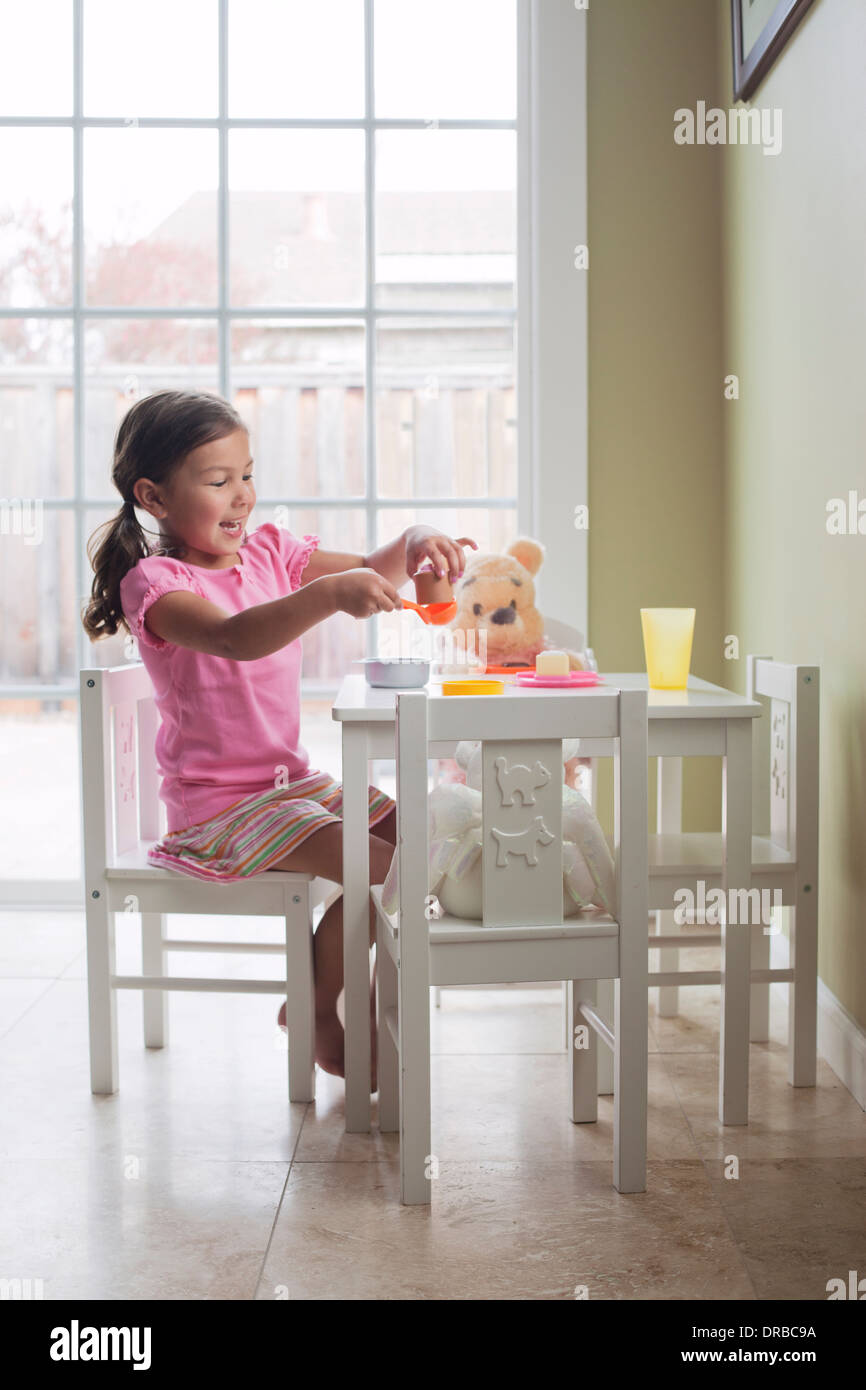 Happy little Girl with toy de la nourriture sur table à manger Banque D'Images