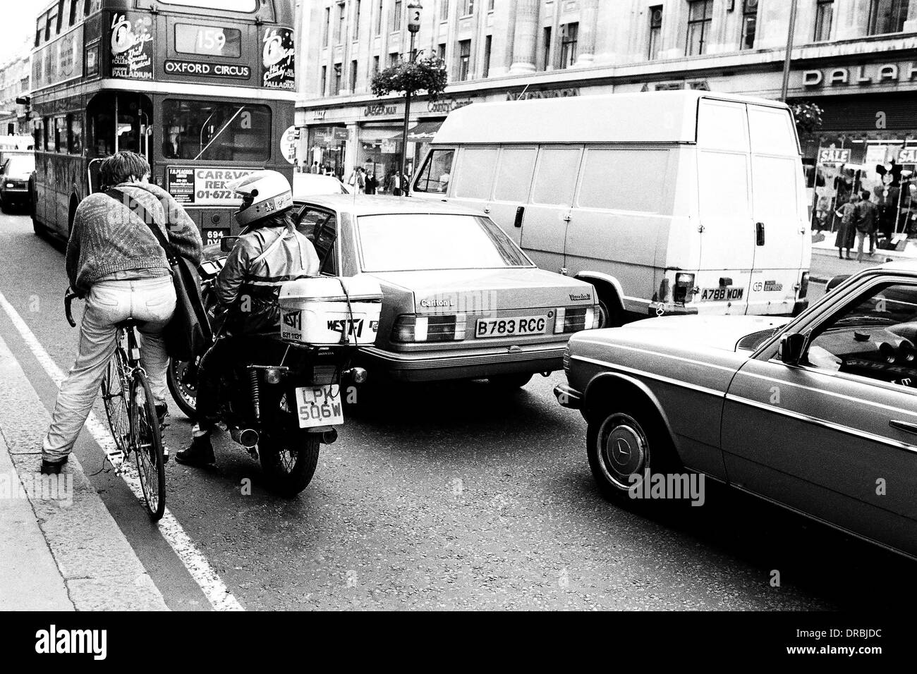 Vélo, moto, voiture, tempo et d'autobus sur la rue de Londres, Angleterre, Royaume-Uni, UK, 1986 Banque D'Images