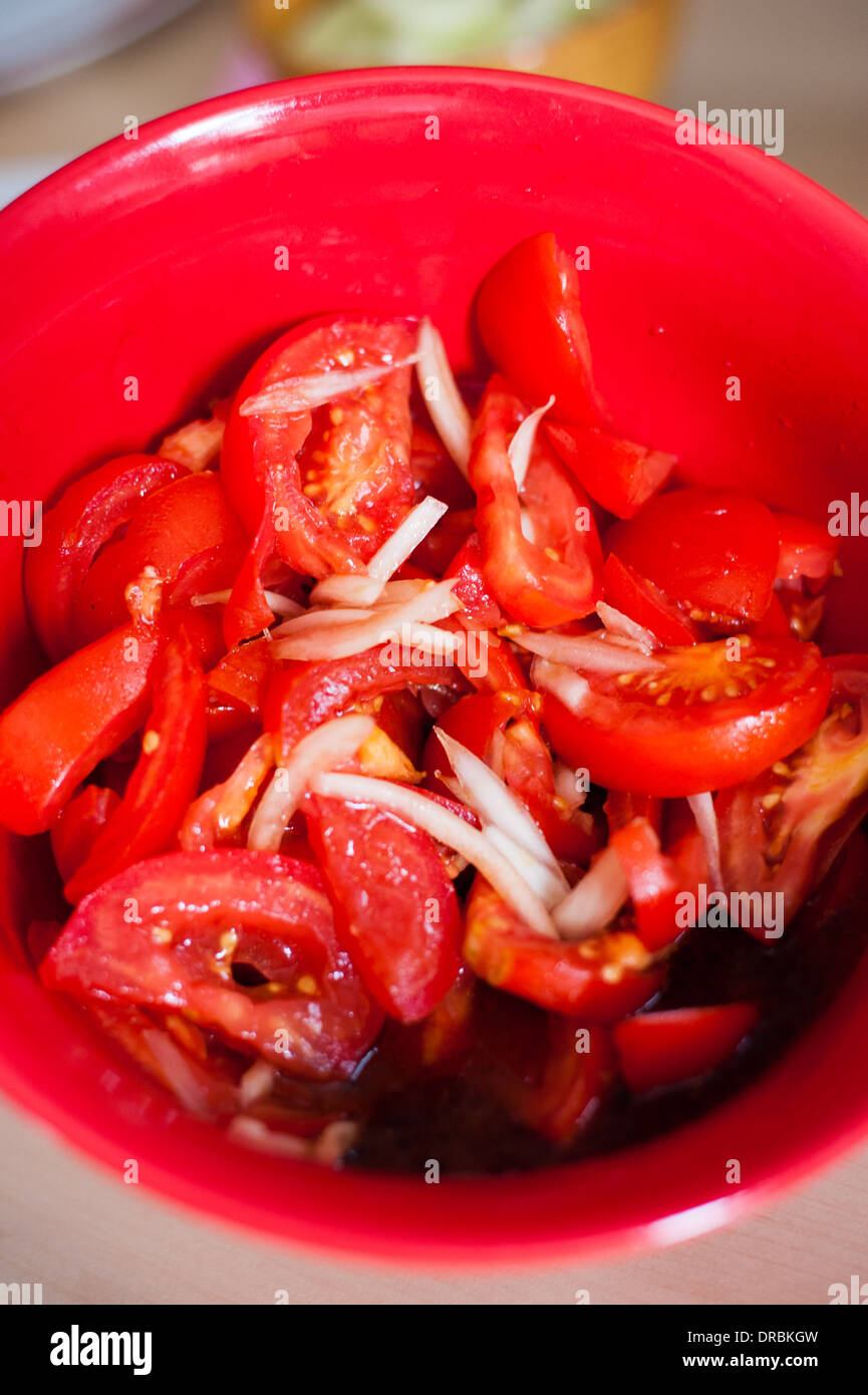 Frais maison salade de tomates et d'oignon dans un bol rouge Banque D'Images