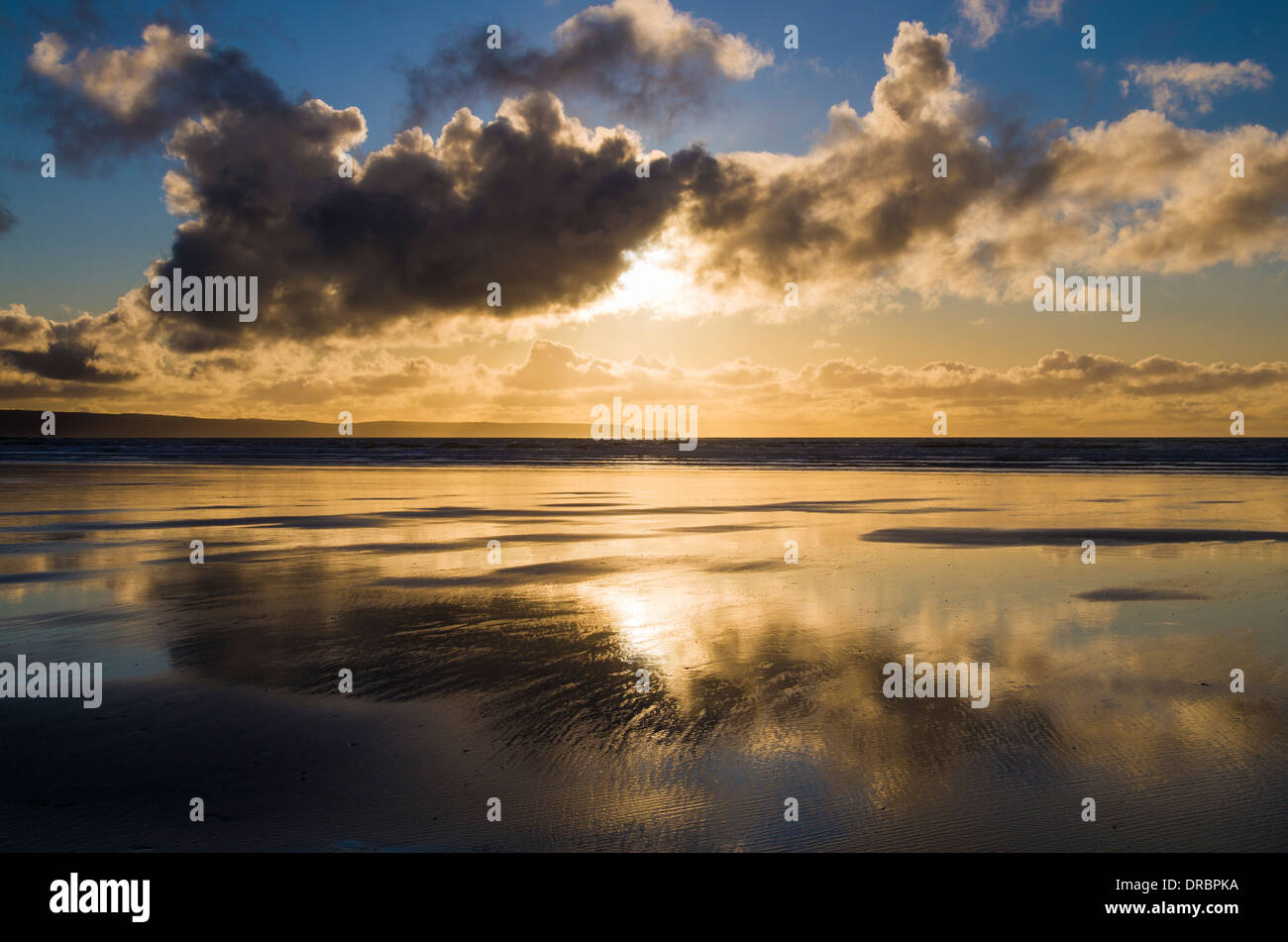 Belle plage coucher du soleil reflétée dans l'eau à marée basse. Westward Ho !, North Devon, Angleterre. Banque D'Images