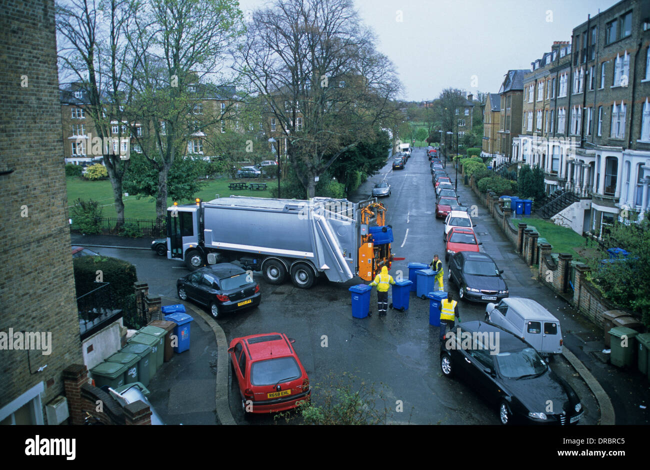 Éboueurs de vider les bacs de recyclage dans une rue de Londres, Angleterre Banque D'Images