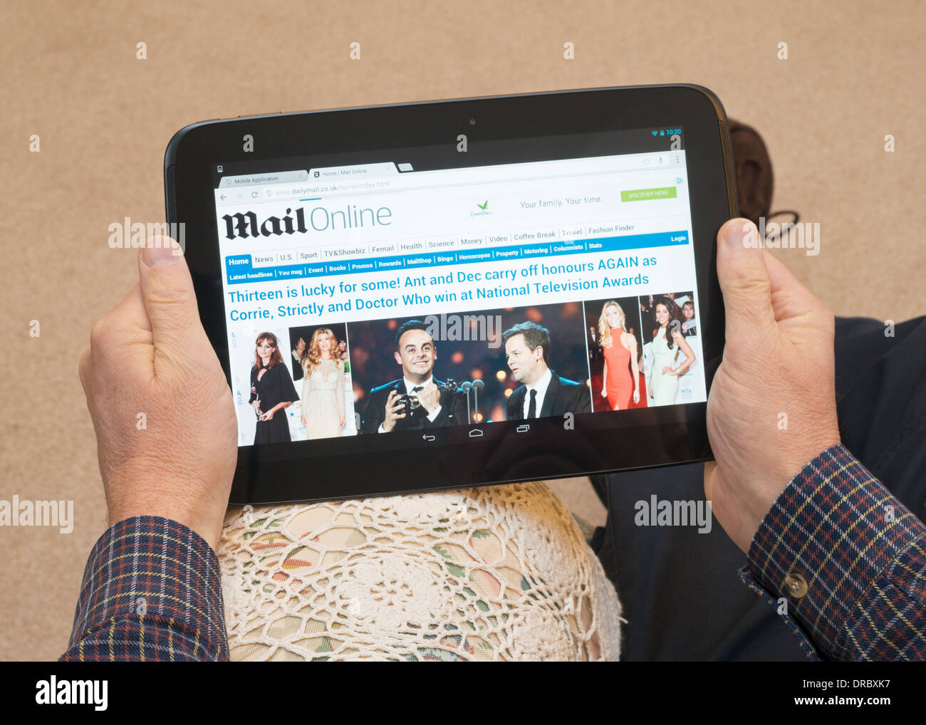 Homme lisant le journal Daily Mail en utilisant Google tablette Nexus 10 Banque D'Images