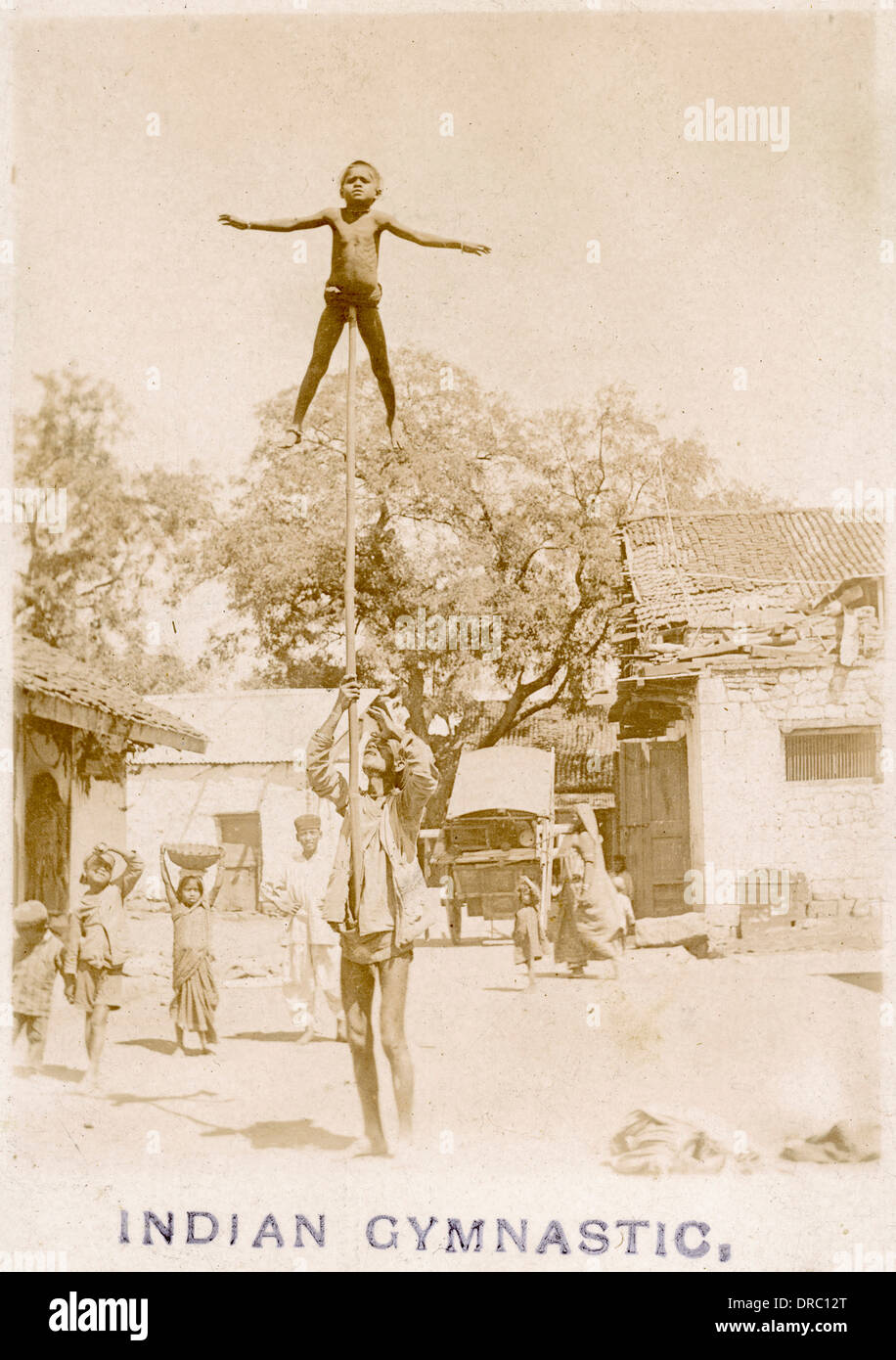 Gymnaste enfant indien au sommet d'une longue perche Banque D'Images