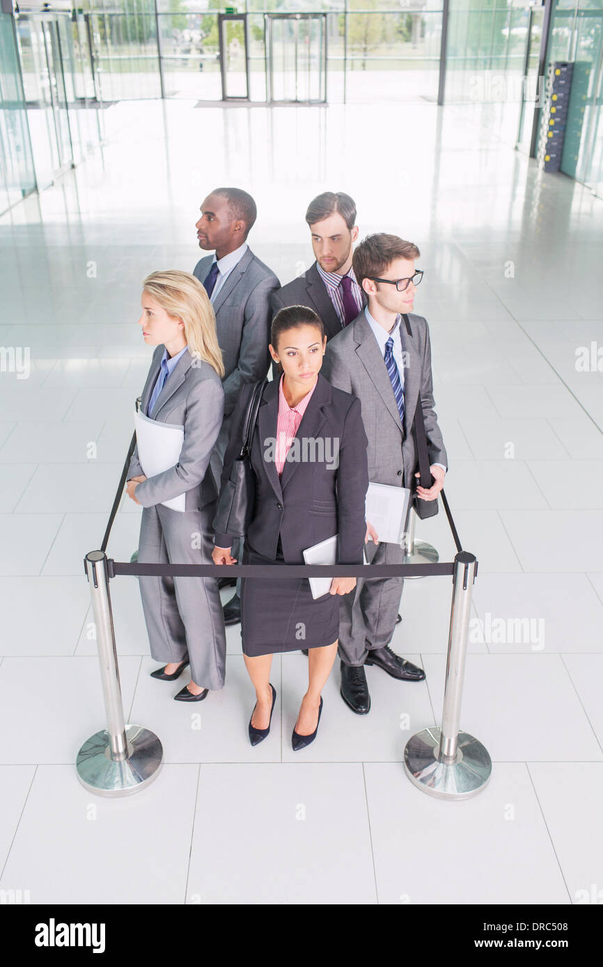 Business people standing in roped-off square Banque D'Images