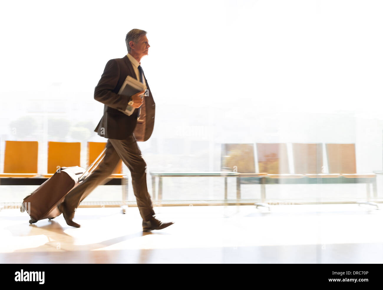 Businessman running avec valise dans le corridor de l'aéroport Banque D'Images