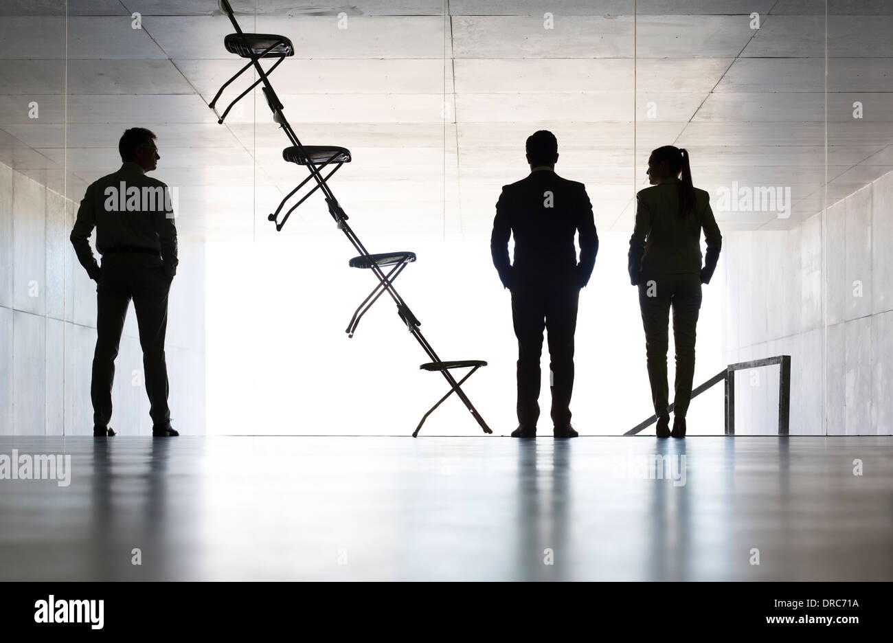 Les gens d'affaires se trouvant à côté d'installation art chaise de bureau Banque D'Images
