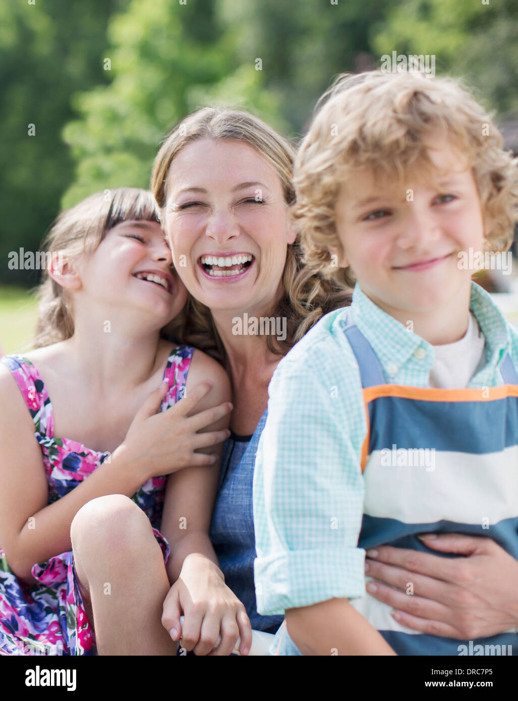 Mère et enfants smiling outdoors Banque D'Images