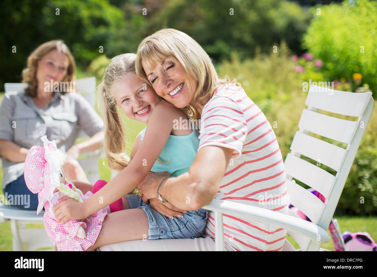 Grand-mère et petite-fille hugging in backyard Banque D'Images