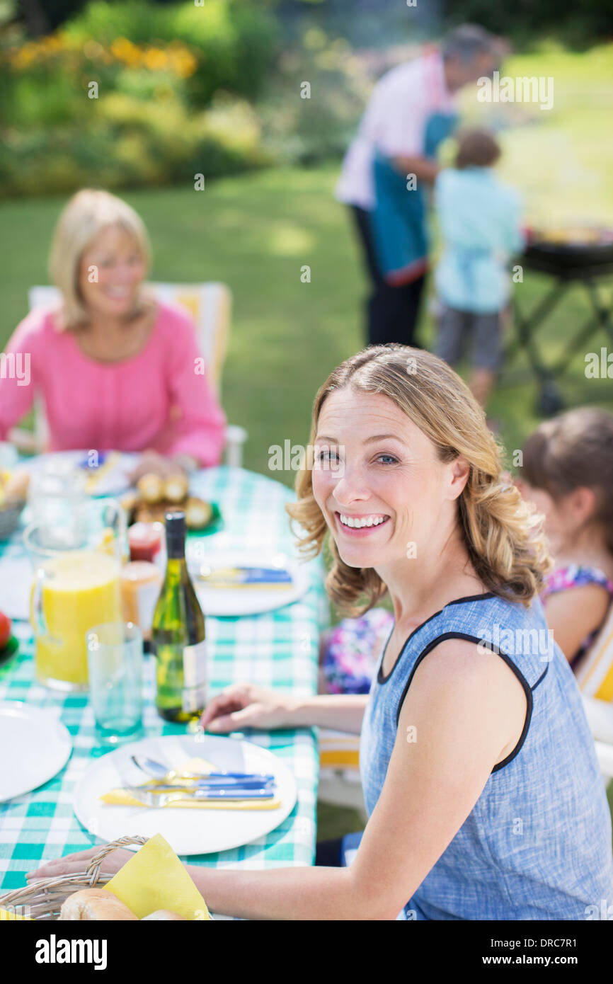 Woman smiling at table in backyard Banque D'Images