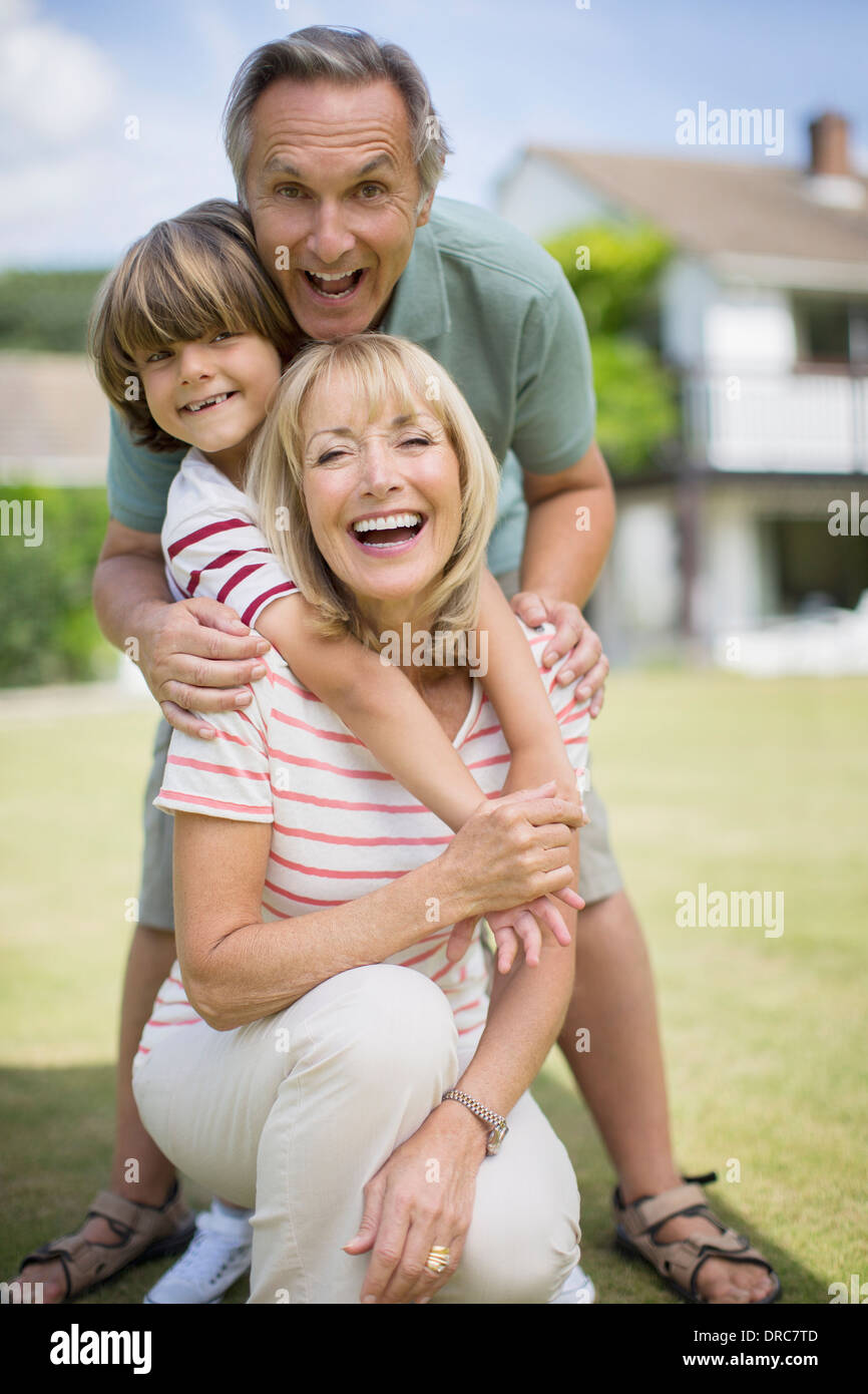 Les grands-parents et petit-fils hugging outdoors Banque D'Images