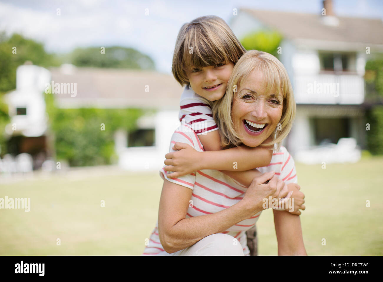 Grand-mère et petit-fils hugging in backyard Banque D'Images
