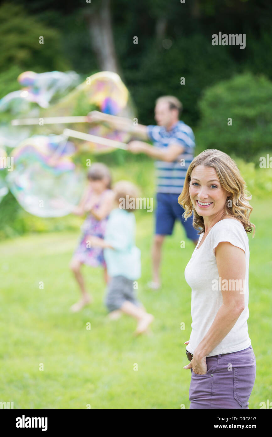 Family Playing with bubbles in backyard Banque D'Images