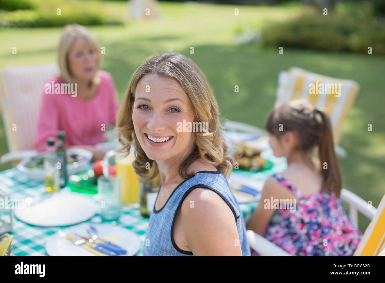 Multi-generation family eating at table in backyard Banque D'Images