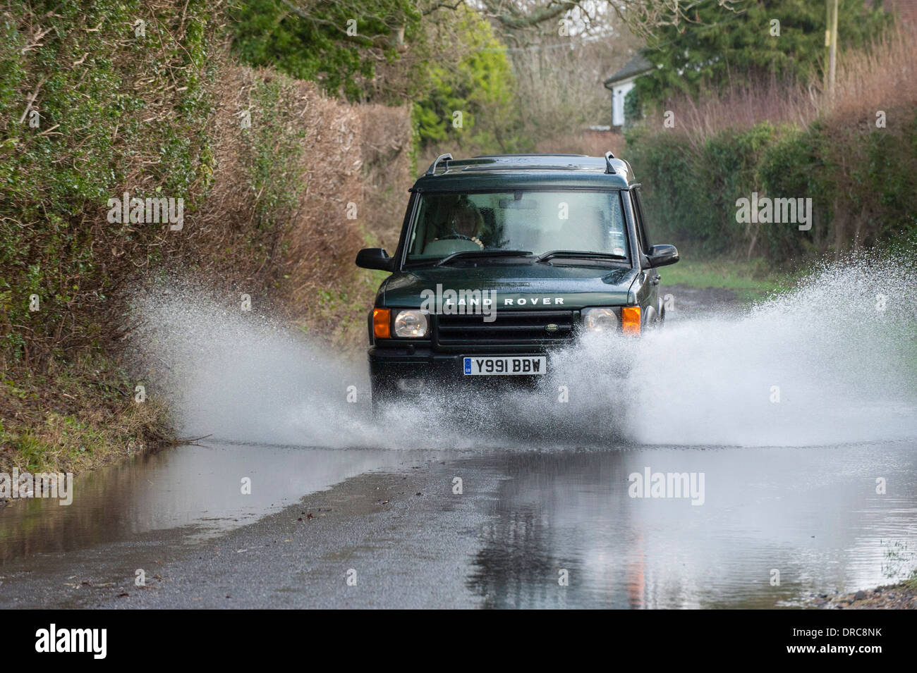 Land Rover Discovery 4x4 roulant dans l'eau d'inondation sur un chemin de campagne, Hampshire, Royaume-Uni Banque D'Images