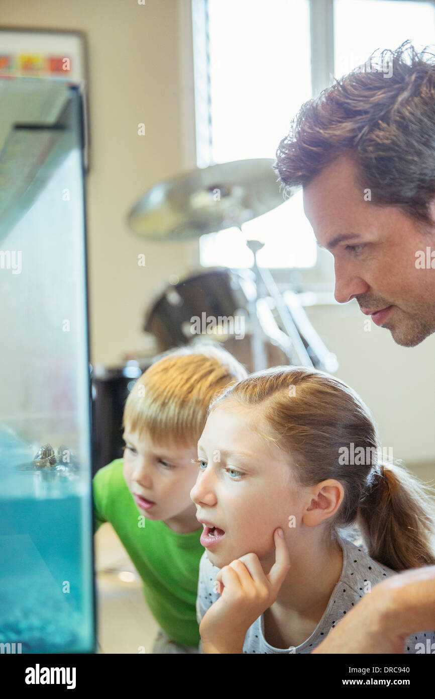 Le père et les enfants l'examen fish tank Banque D'Images