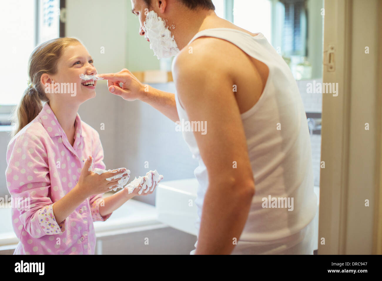 Père et fille jouer avec la crème à raser Banque D'Images