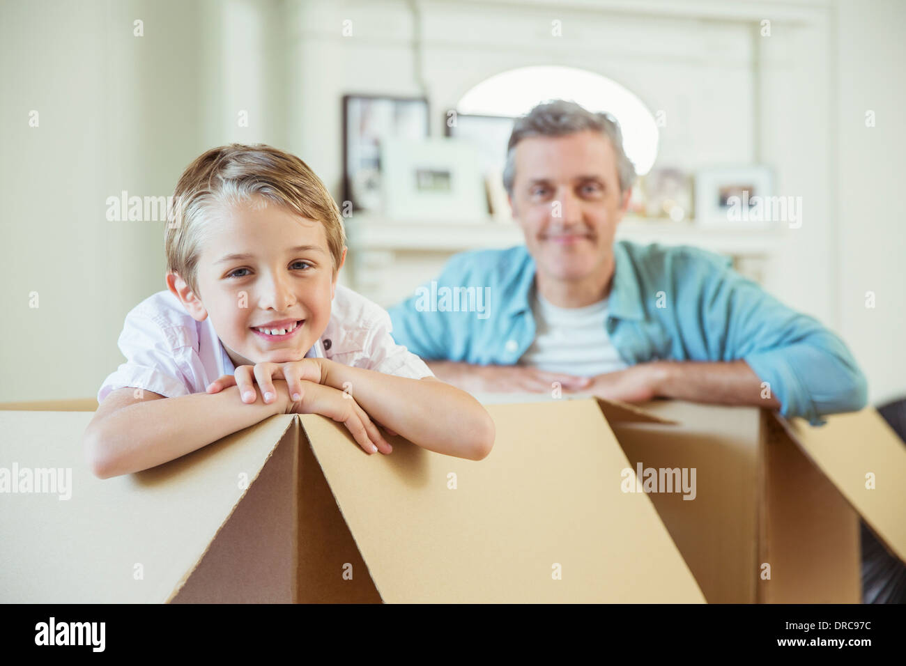 Père et fils jouant dans des boîtes de carton Banque D'Images Père et fils jouant dans des boîtes de carton Banque D'Images