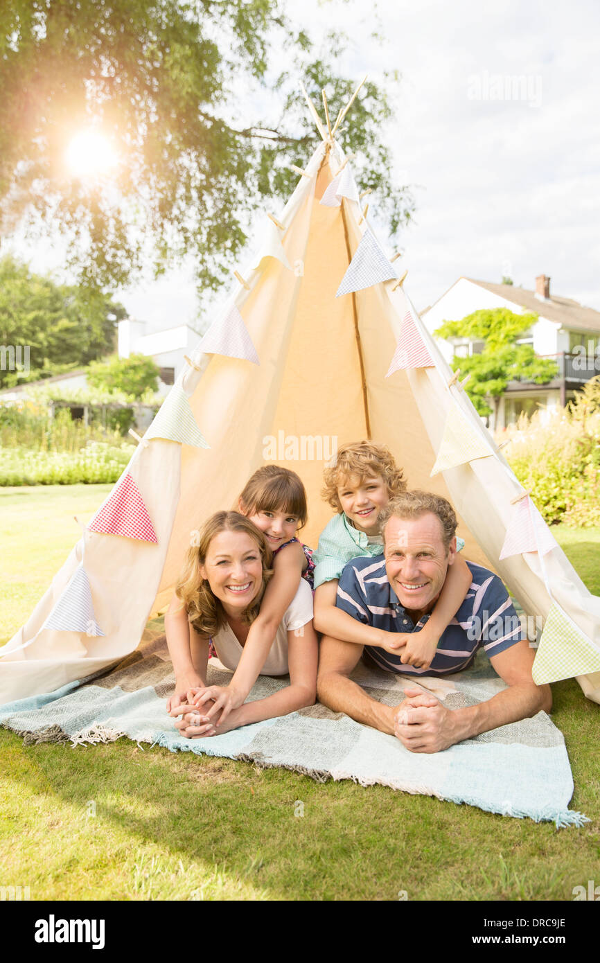 Family relaxing in tipi in backyard Banque D'Images