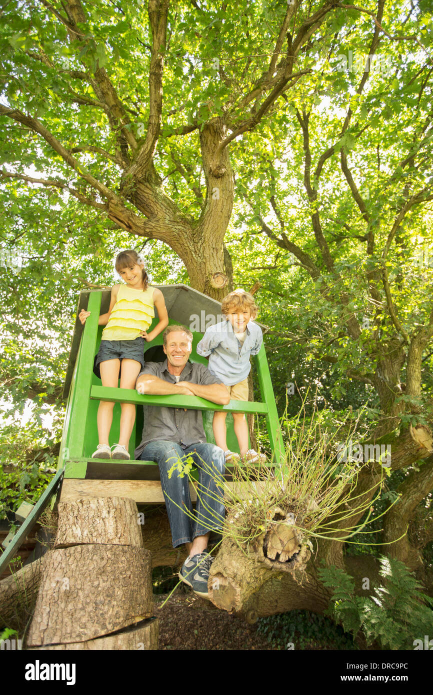 Le père et les enfants jouant dans treehouse Banque D'Images