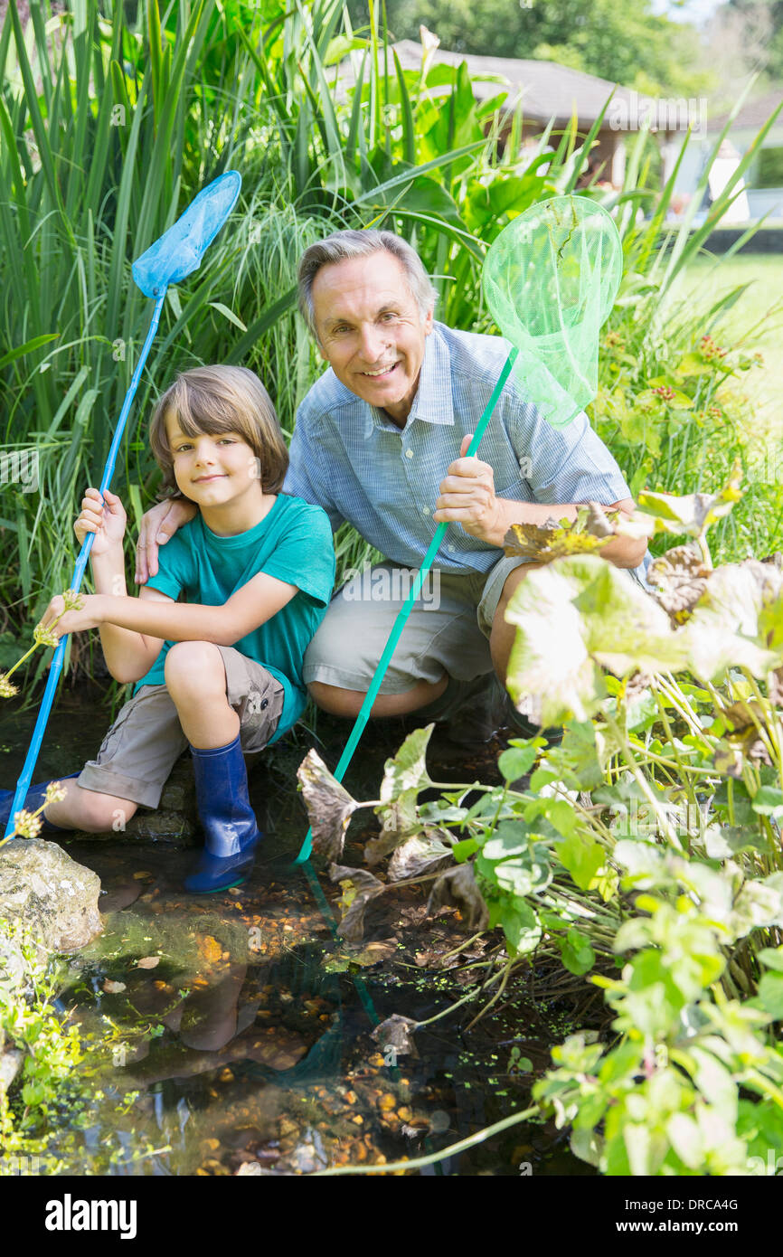 Grand-père et petit-fils de pêche dans étang Banque D'Images