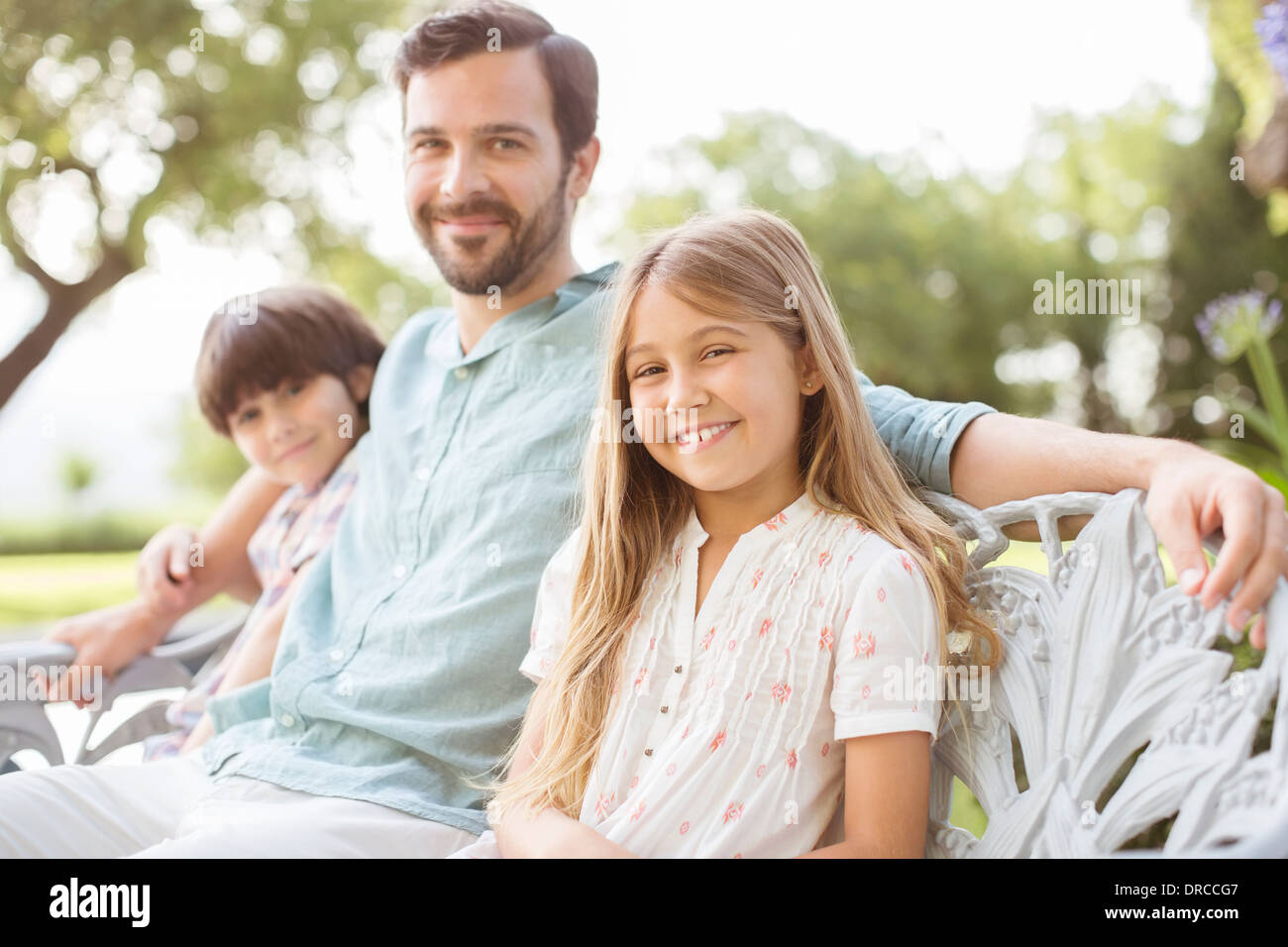 Père et enfants sourire sur le banc Banque D'Images