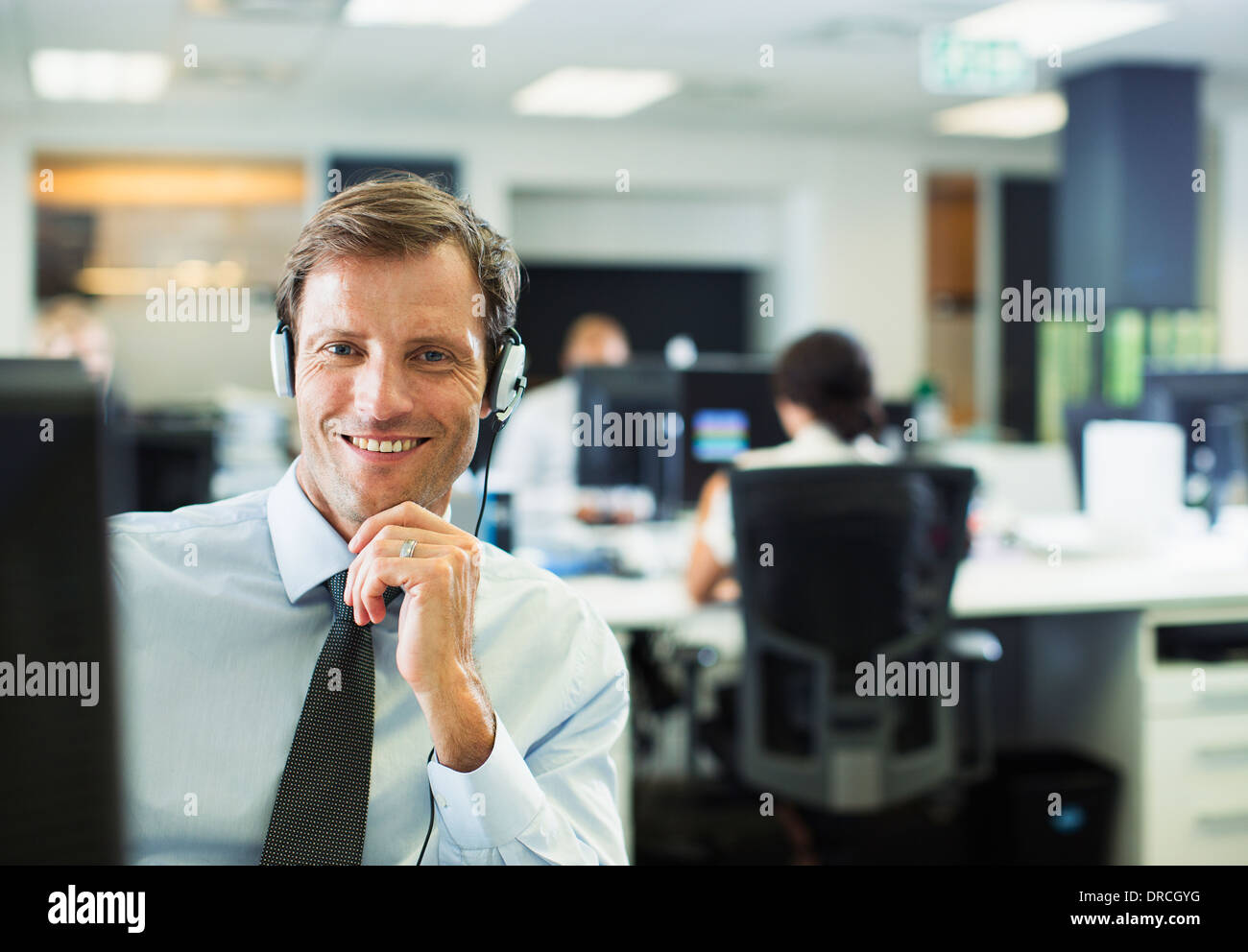 Businessman wearing headset in office Banque D'Images