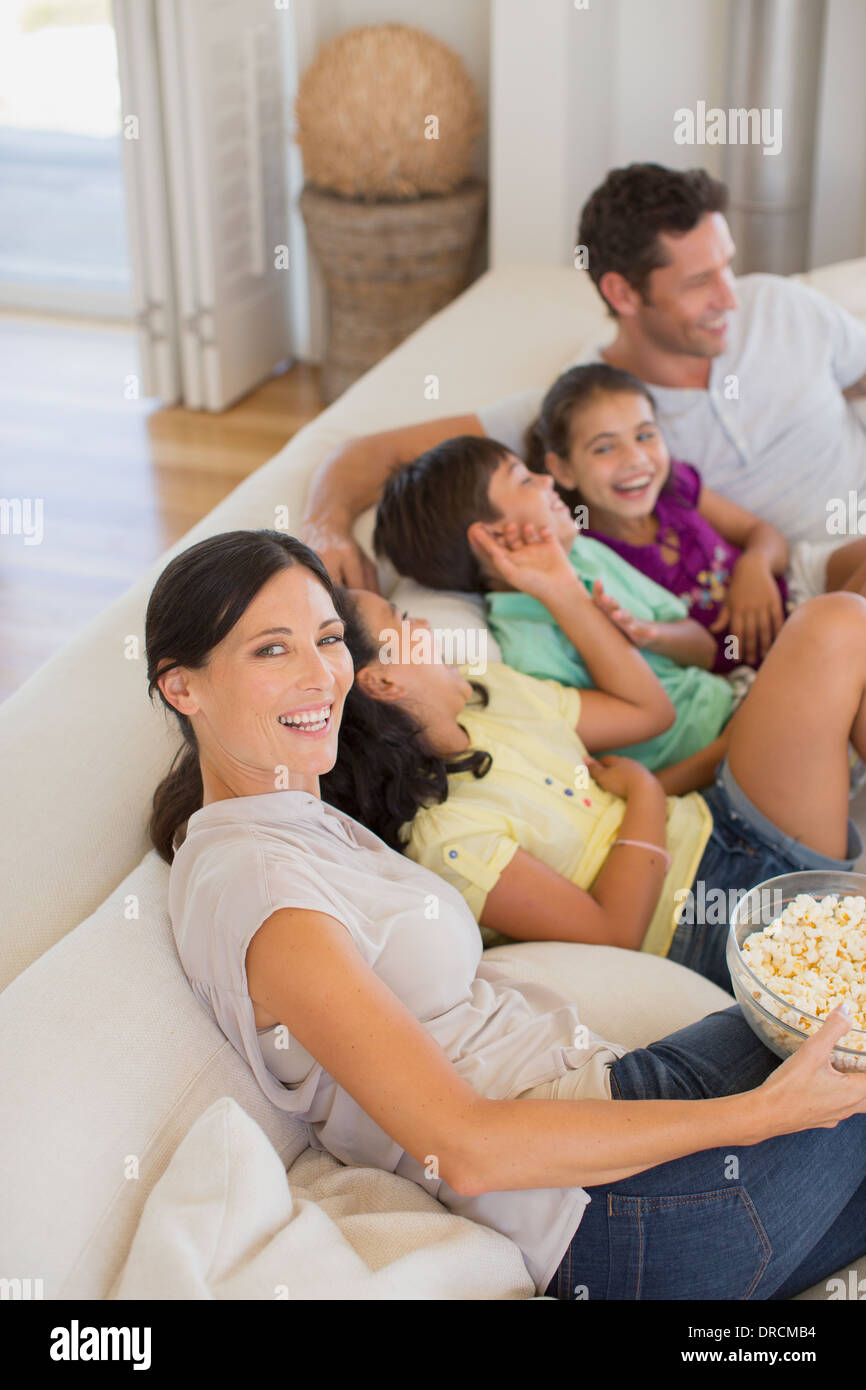 Rire de la famille sur un canapé dans la salle de séjour Banque D'Images