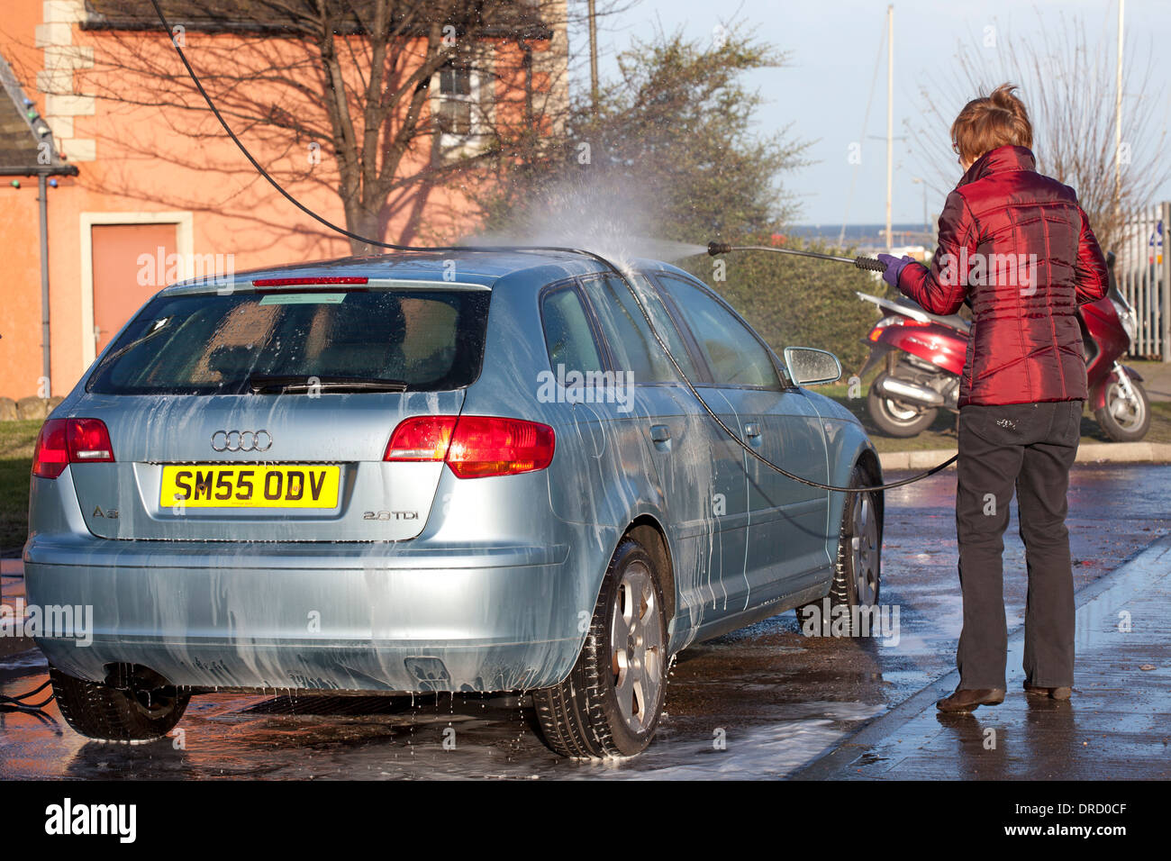 Femme lave-auto avec jet de pulvérisation lavage Banque D'Images