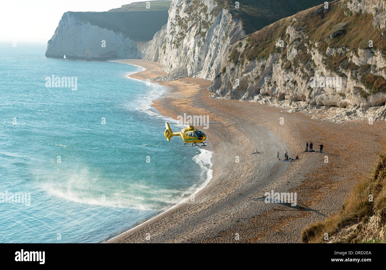 Dorset et Somerset Air Ambulance secourir une dame à Durdle Door Beach sur la Côte Jurassique, près de crique de Lulworth, Dorset, England, UK Banque D'Images