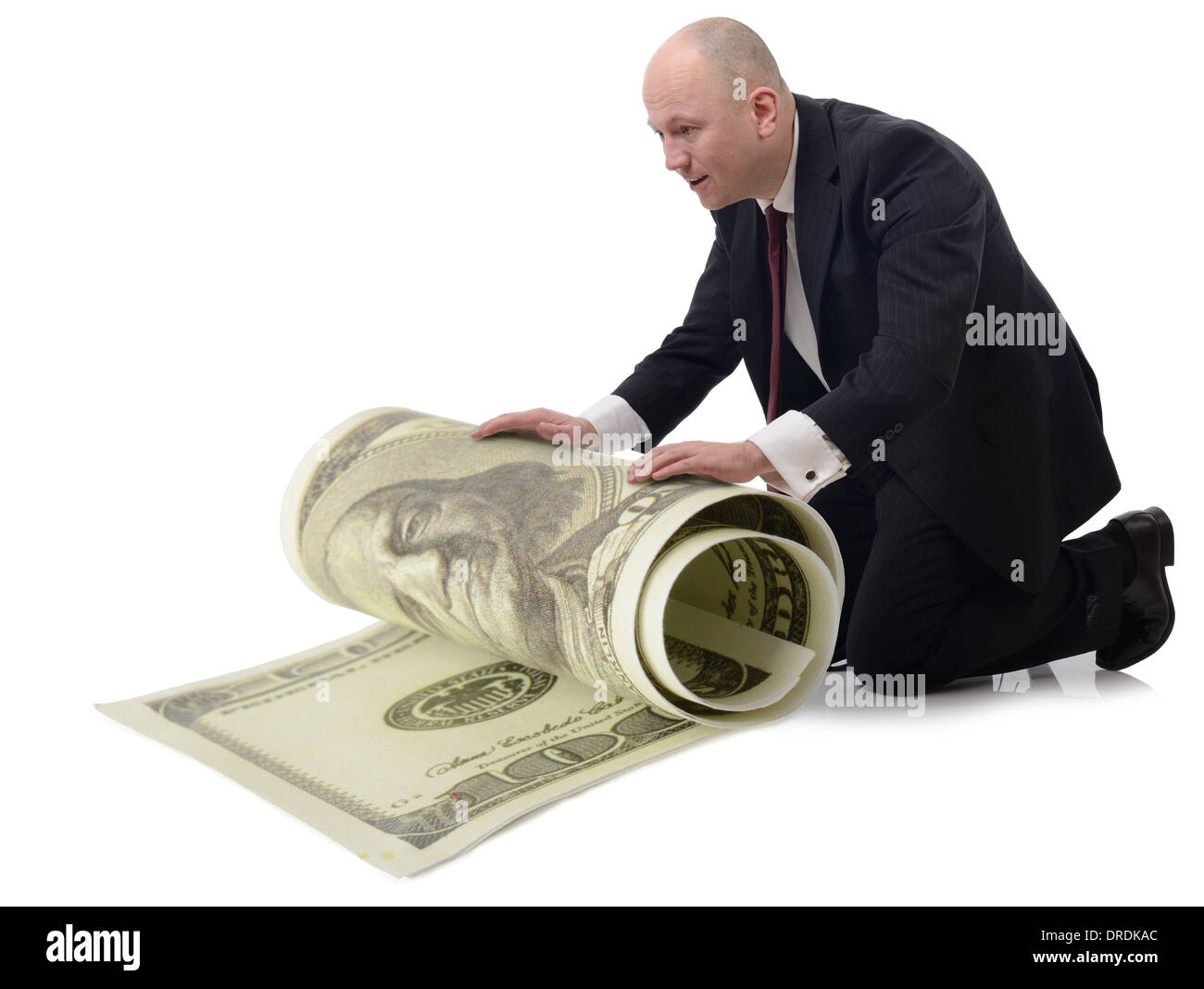 En prenant soin d'argent un homme rouler un grand 100 dollar bill isolé sur un fond blanc. Banque D'Images