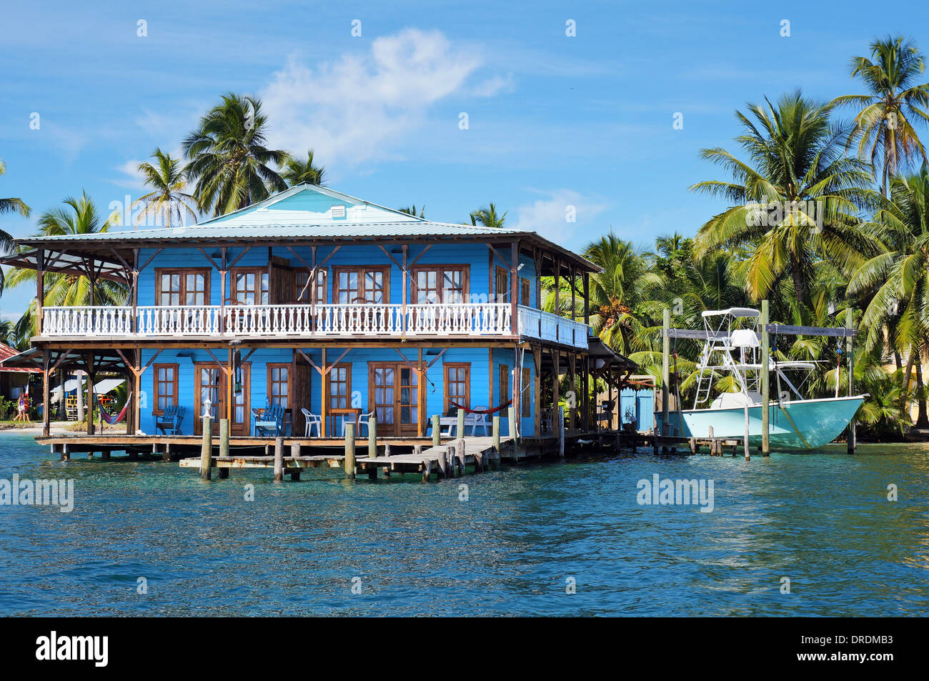 Belle maison tropicale sur pilotis sur la mer des Caraïbes avec un bateau et des cocotiers, le Panama Banque D'Images