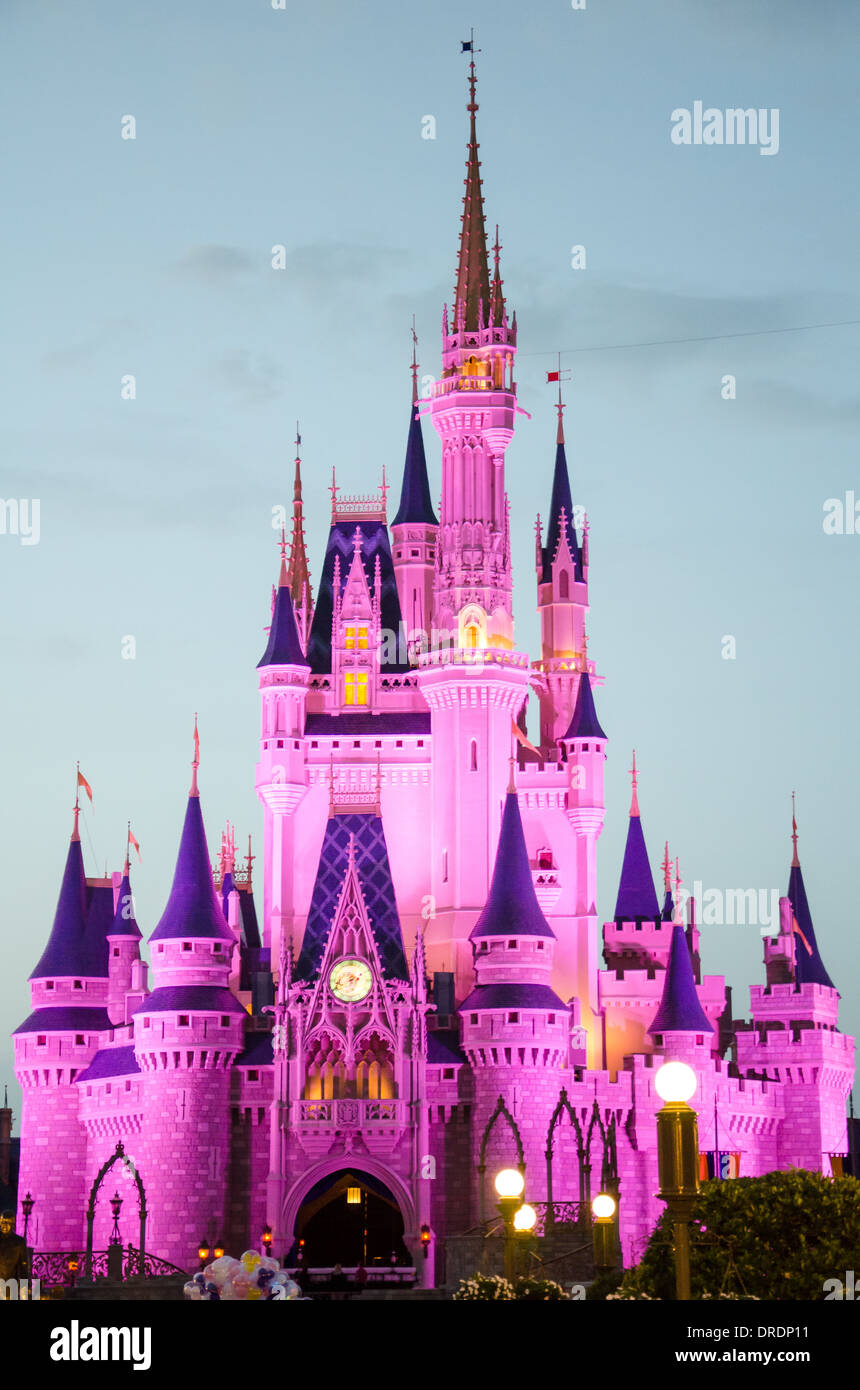 Le château de Magic Kingdom à Walt Disney World, Orlando, Floride éclairée le début de soirée. Banque D'Images