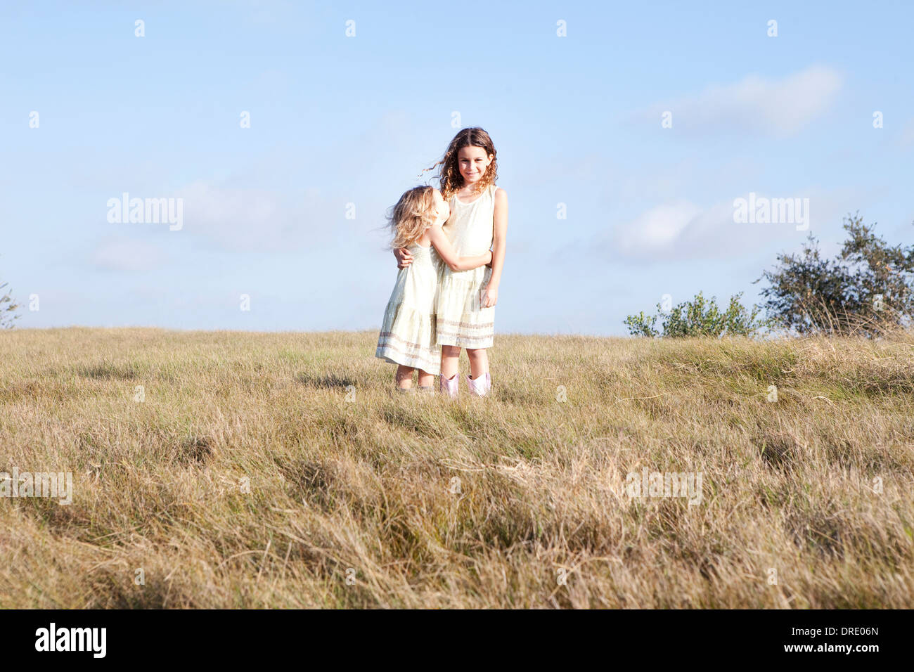 Soeurs en robes standing in field Banque D'Images