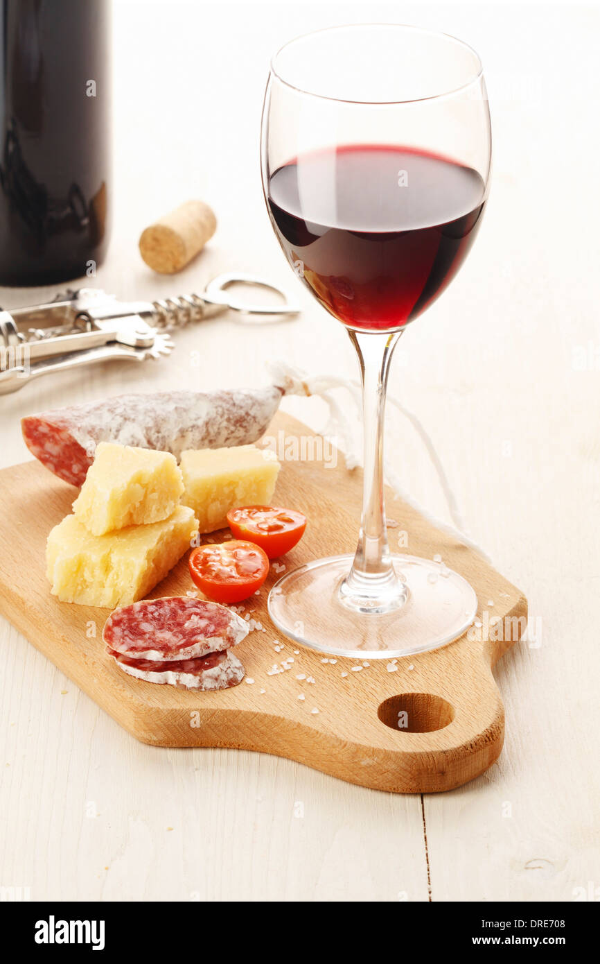 Vin rouge et assortiment de fromages et des collations sur fond blanc Banque D'Images