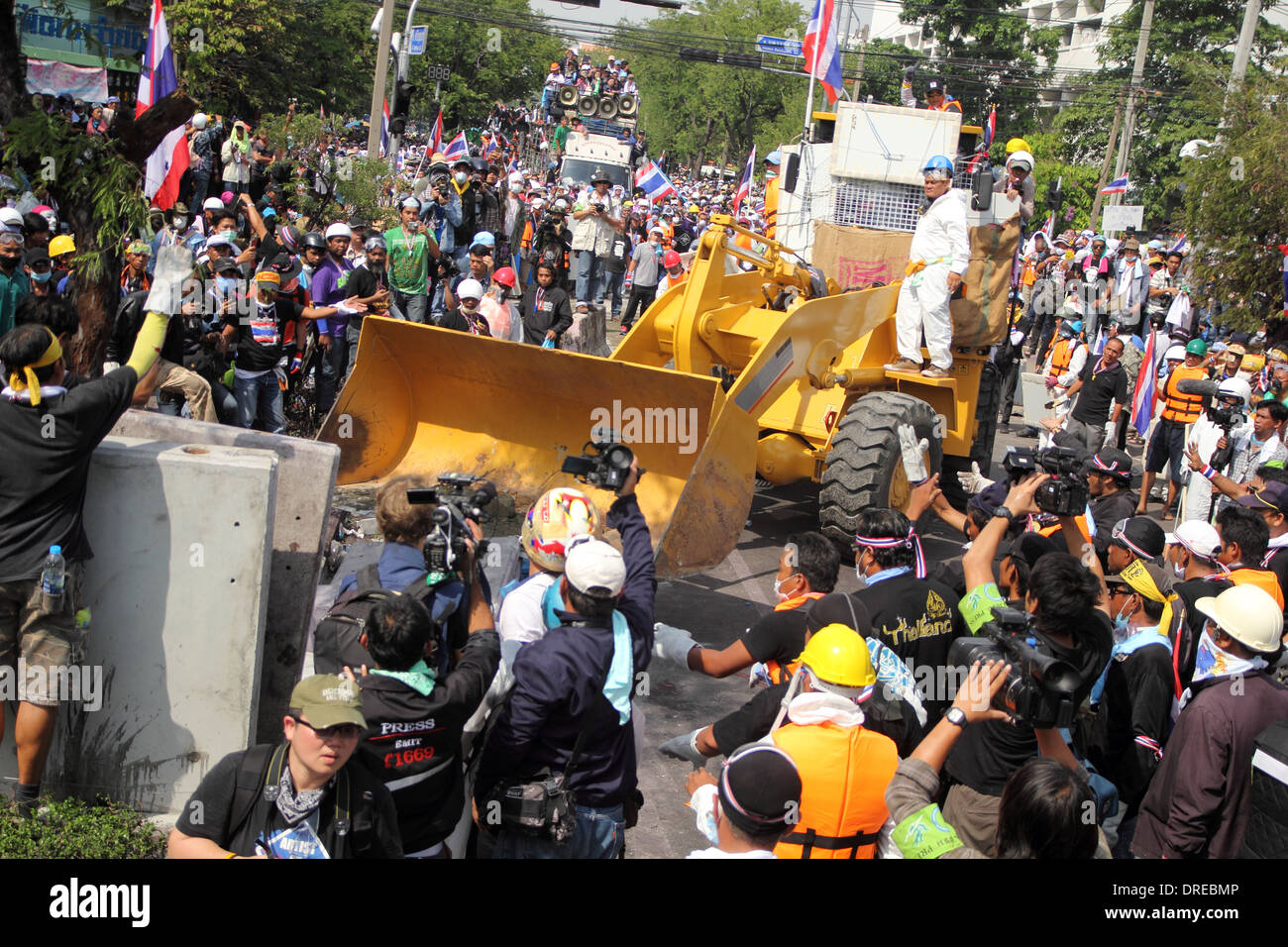 Des manifestants anti-gouvernement pousser un fil barbelé sur la route menant à la Metropolitan Police à Bangkok. Banque D'Images