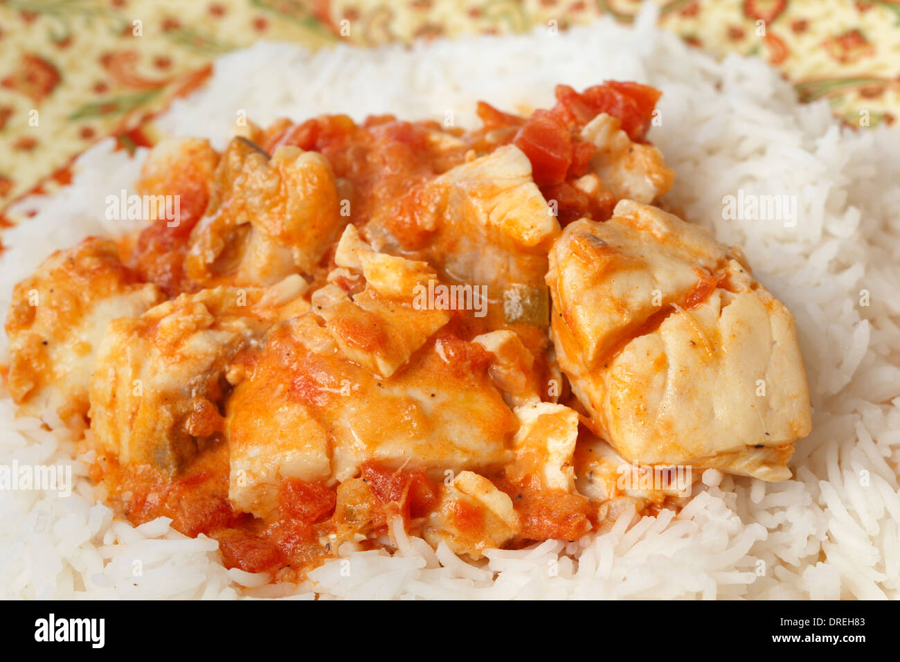Curry de poisson de base, dans une sauce tomate et le lait de coco, servi sur un lit de riz basmati. Banque D'Images