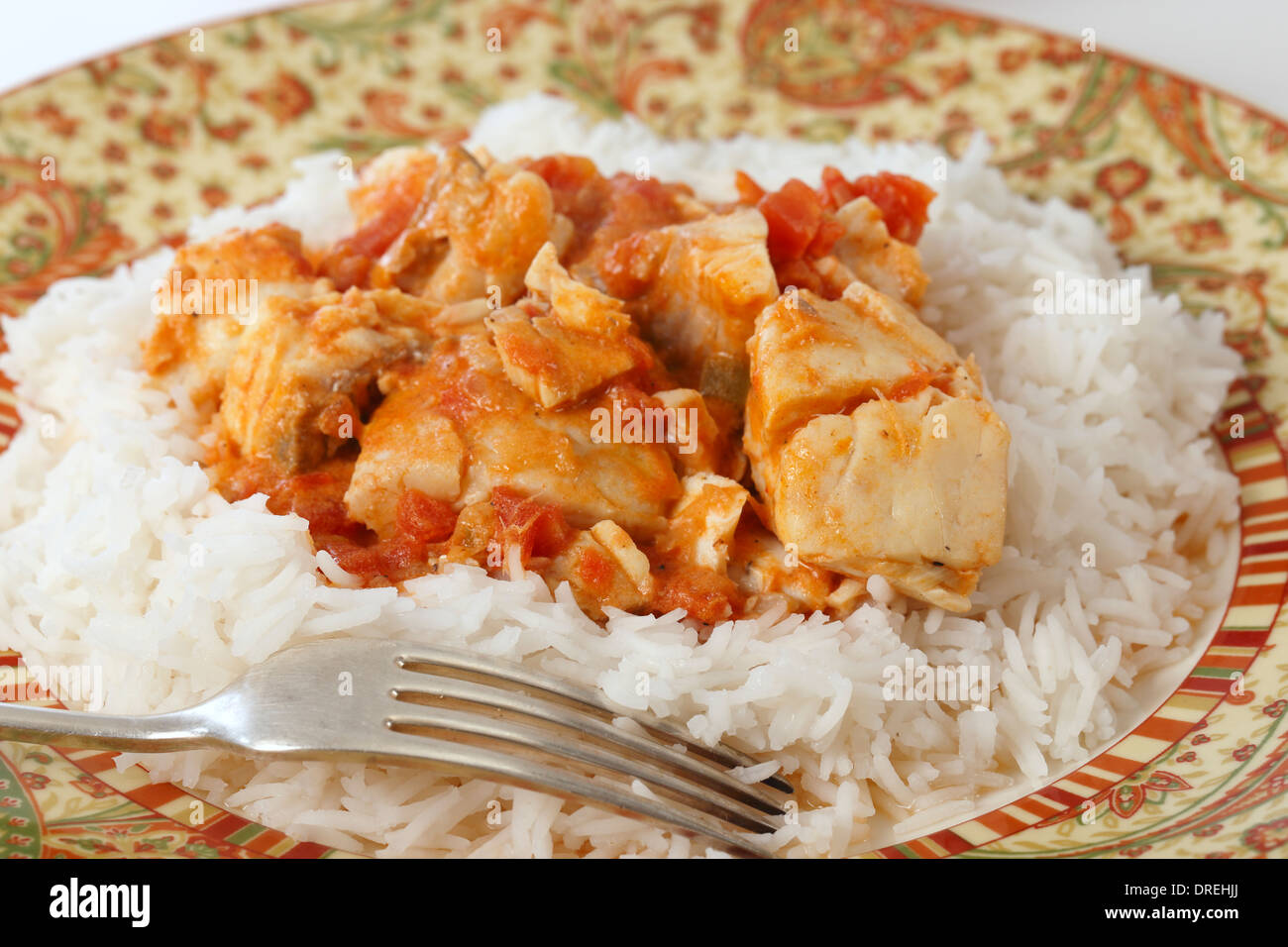 Curry de poisson de base, dans une sauce tomate et le lait de coco, servi sur un lit de riz basmati. Banque D'Images