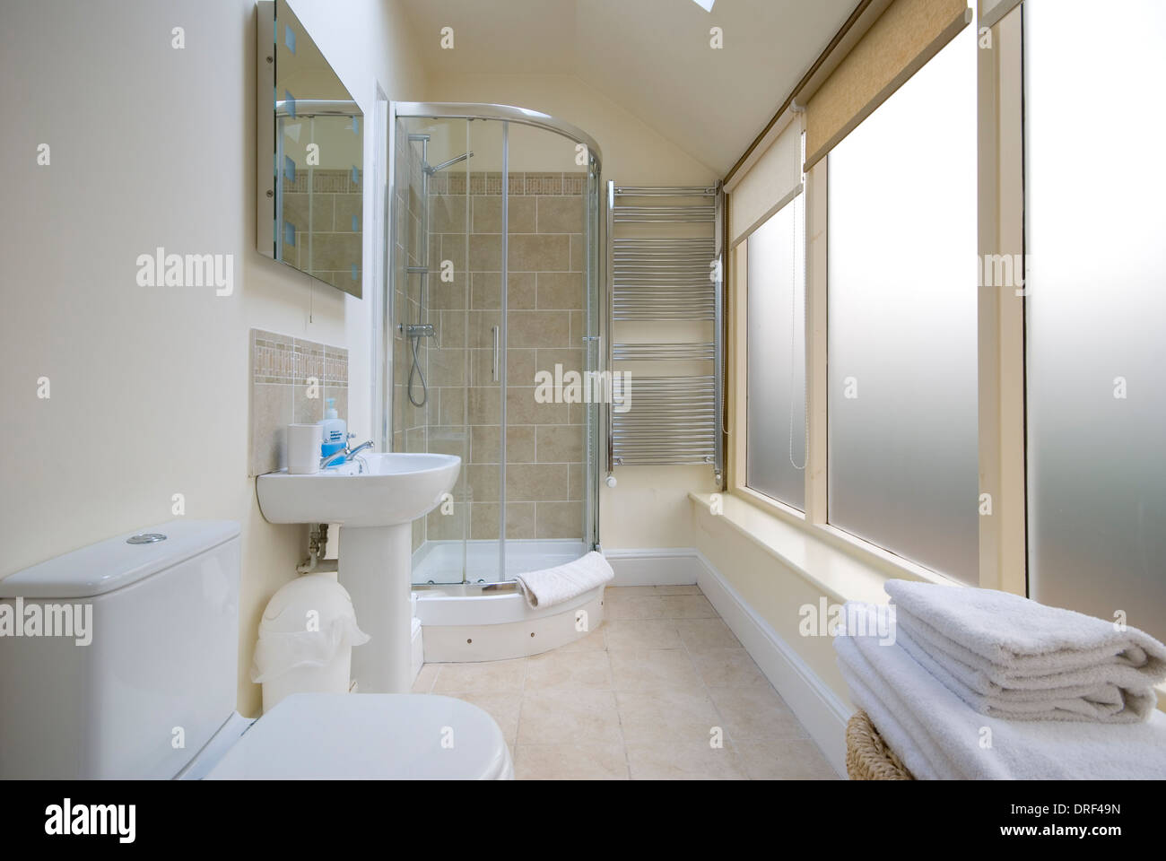 Salle de douche longue et fine avec de grandes fenêtres opaques Banque D'Images