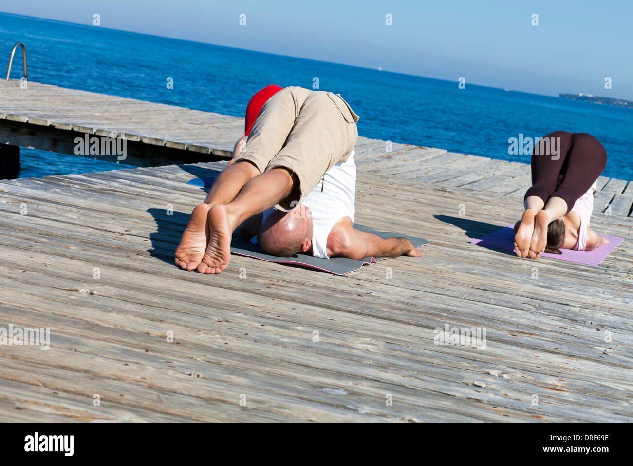 Les personnes pratiquant le yoga sur le Boardwalk, charrue poser Banque D'Images