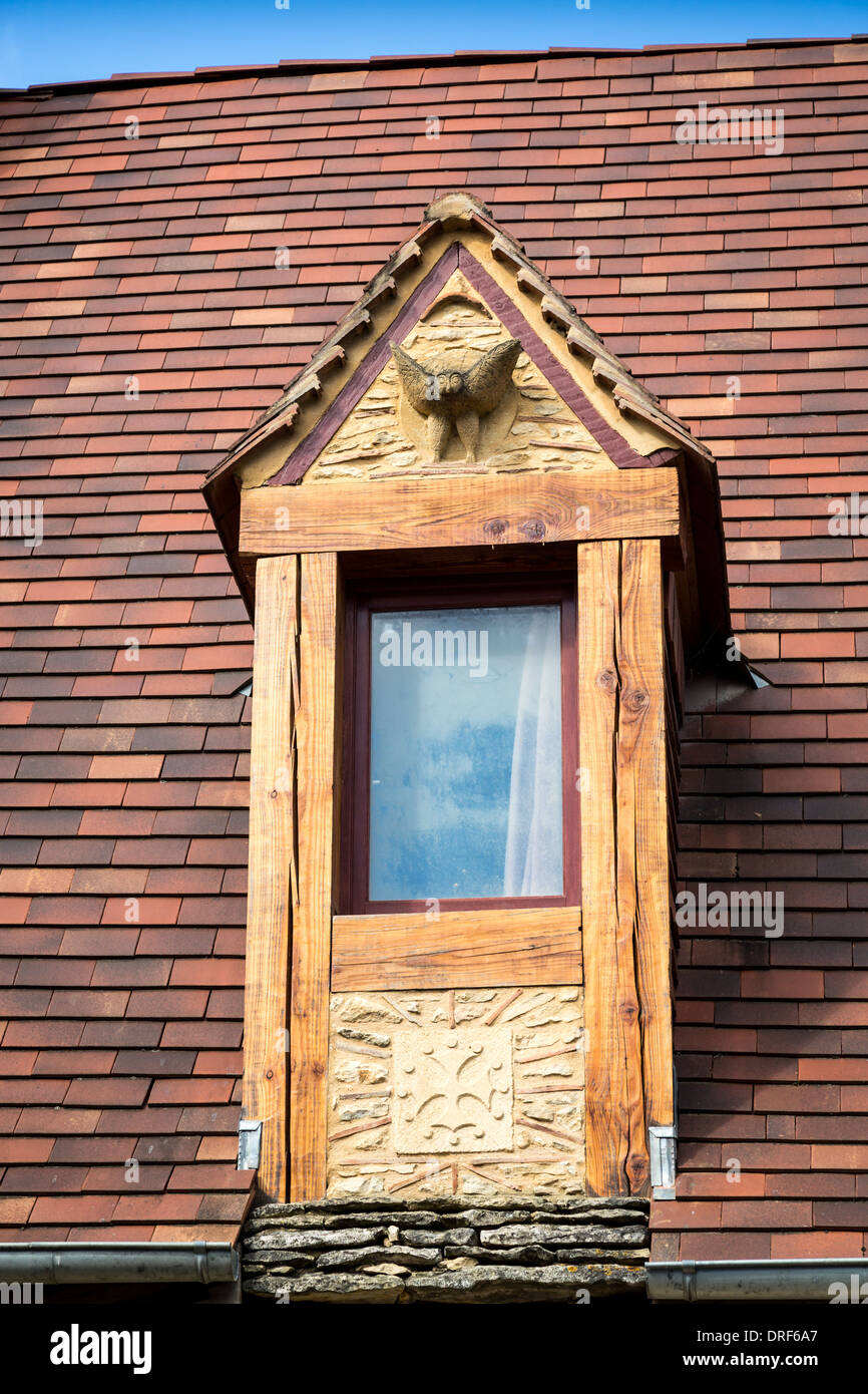 Domme, Dordogne, France, Europe. Fenêtre en bois marqueté avec de la sculpture sur pierre situé dans le toit d'une maison traditionnelle en pierre. Banque D'Images