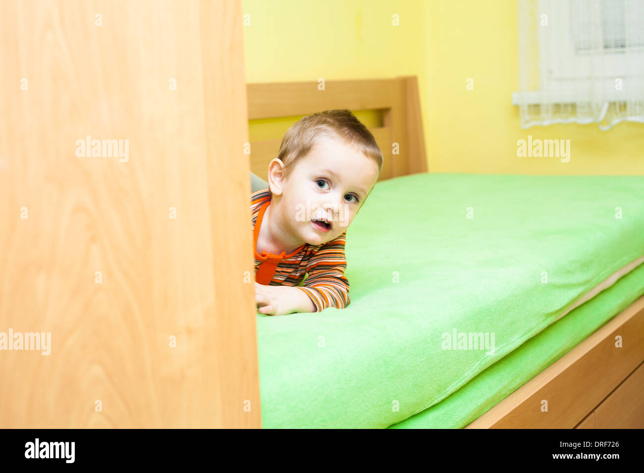 Cute child boy lying on bed at home Banque D'Images