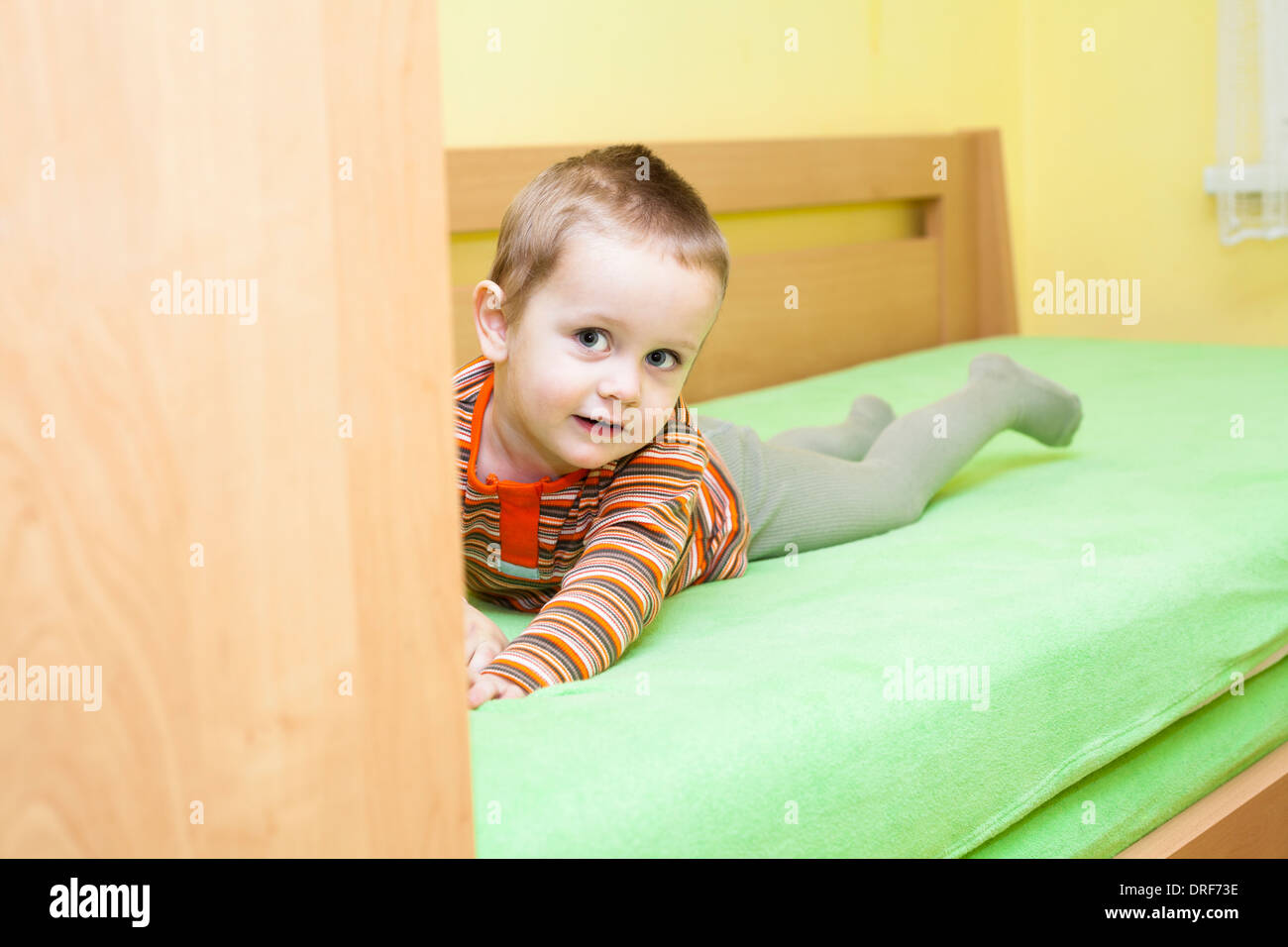 Cute child boy lying on bed at home Banque D'Images