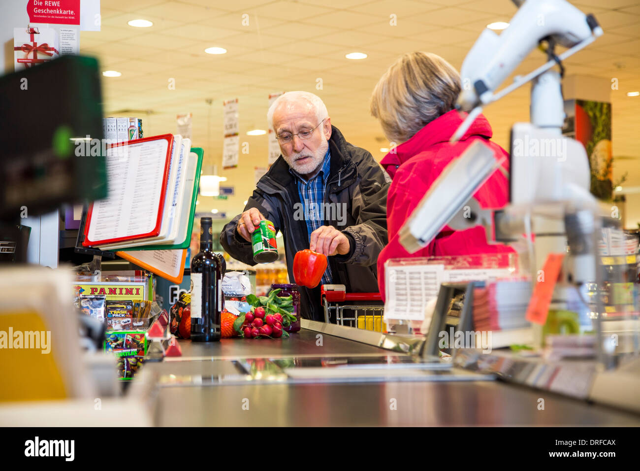 Vieux couple achète dans un supermarché, le caissier, à la caisse. Banque D'Images