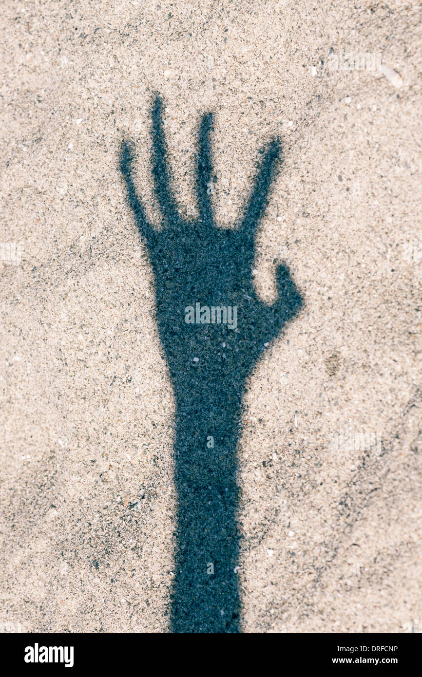 Scary ombre de main sur fond de sable Banque D'Images