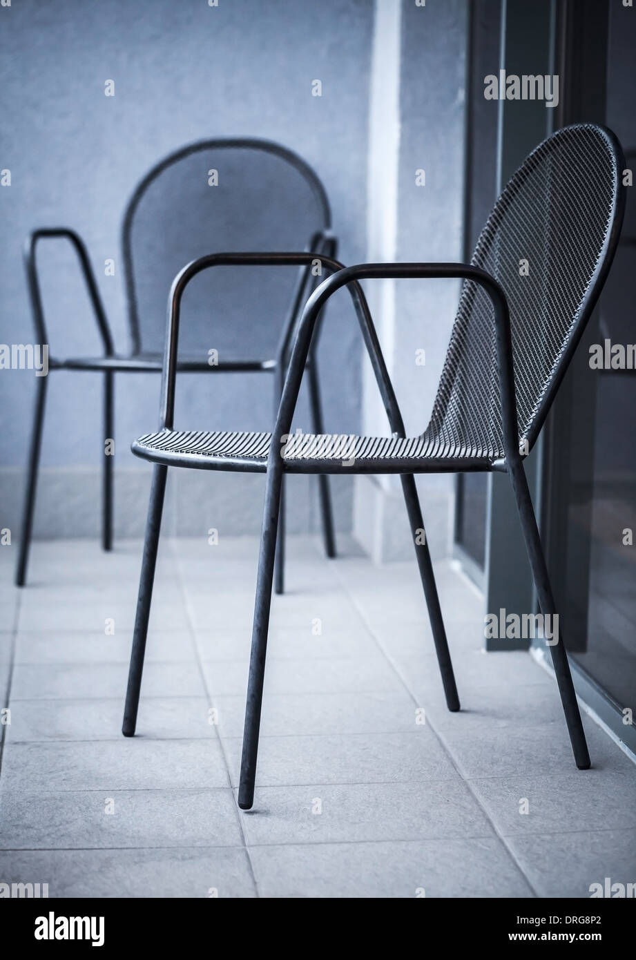 Black metal ordinaire stand chaises sur le balcon Banque D'Images