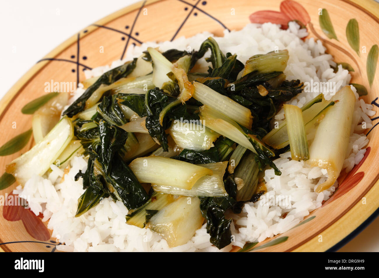 Une plaque avec le bok choi sauté de chou asiatique et haché avec l'huile de sésame et la sauce de soja, servi sur un lit de riz au jasmin blanc Banque D'Images
