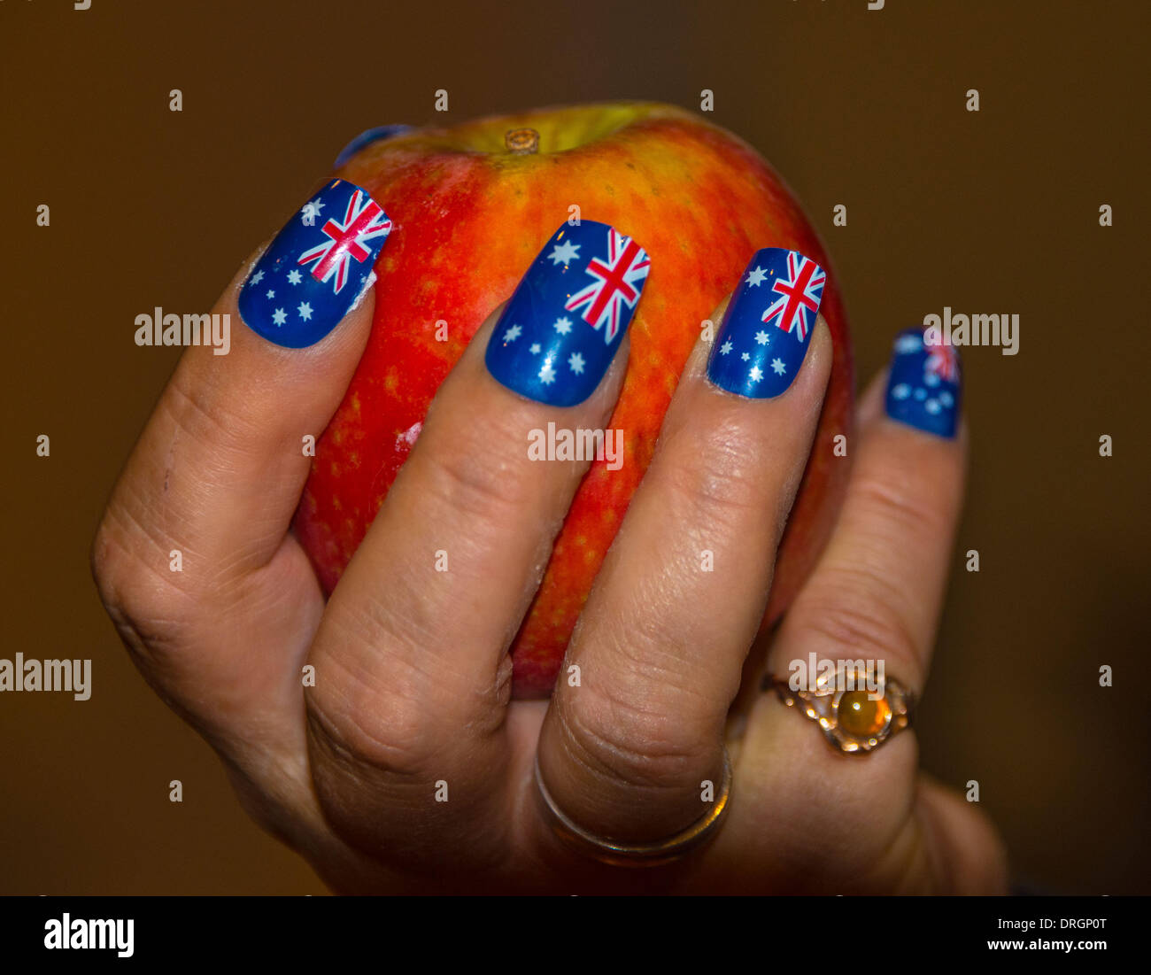 Hand holding apple avec nail art du drapeau australien avec le modèle de presse Banque D'Images