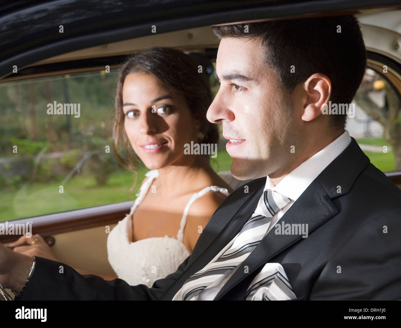 Couple marié dans une voiture. Les lecteurs de l'homme et la femme est de le regarder Banque D'Images