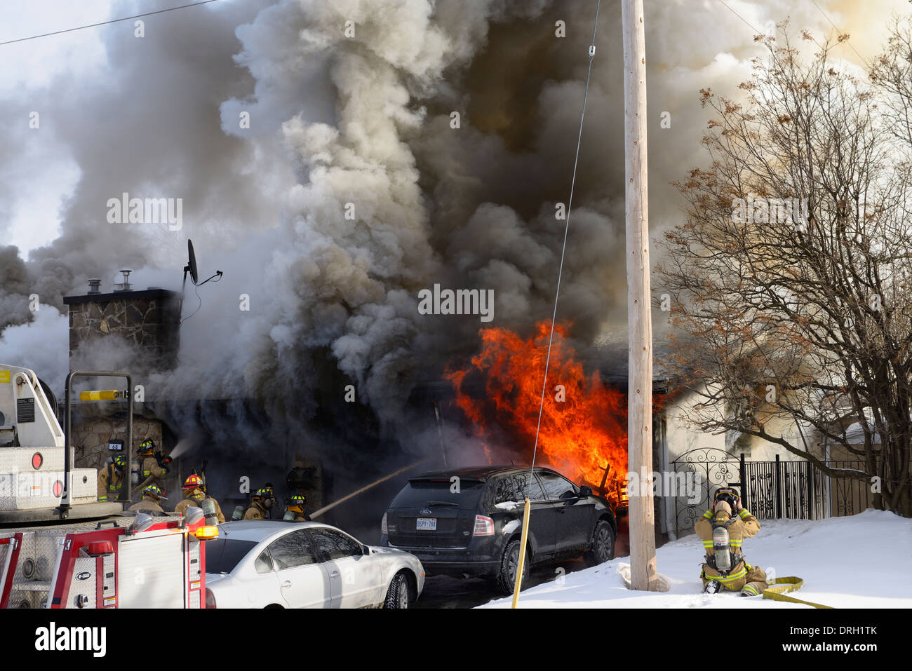 Les pompiers luttent pour abattre un feu de cheminée en hiver maison structurel avec des flammes et de la fumée Ottawa Canada Banque D'Images