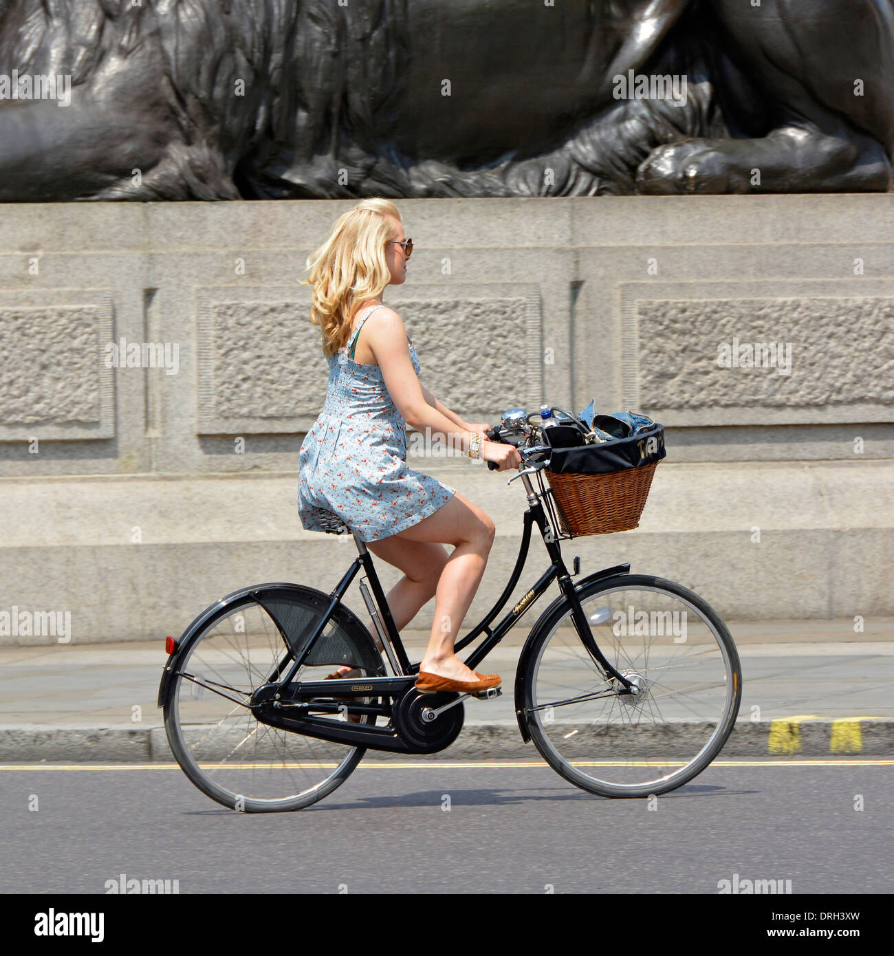 Young woman riding a Pashley Princess chers Vélo Hybride classique avec panier en osier fixé au guidon Banque D'Images